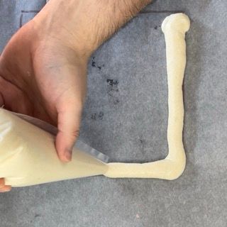 Una persona sta realizzando una lettera l con la glassa