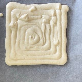 Un pezzo di cibo quadrato con un vortice sopra