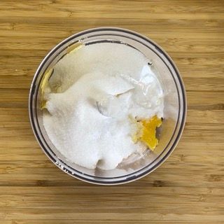 Una ciotola di zucchero e succo di limone su un tavolo di legno