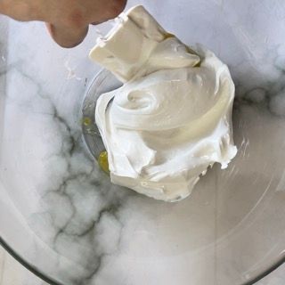 Una persona sta mangiando panna montata da una ciotola.