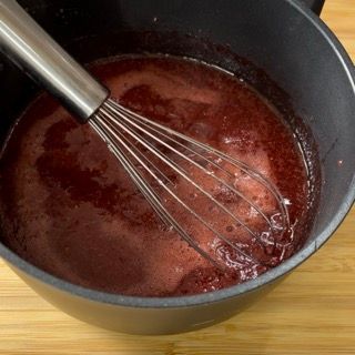 Una frusta è in una pentola di liquido rosso