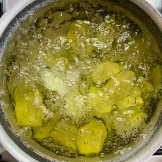 Una pentola di liquido giallo bolle su un fornello