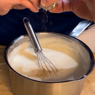 Noce moscata grattugiata fresca sulla superficie della salsa.