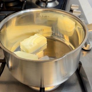 Pezzetti di burro in un pentolino su fiamma bassa.