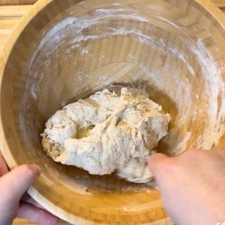 Una persona sta mescolando l'impasto in una ciotola di legno