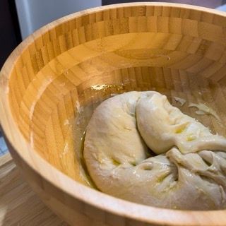 Una ciotola di legno con dentro un pezzo di pasta