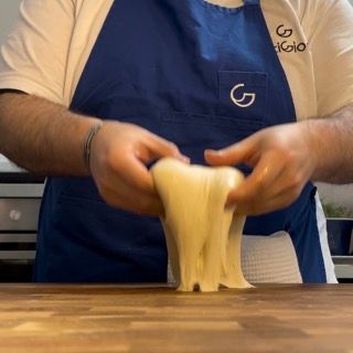 Una persona che indossa un grembiule blu con la lettera g sopra