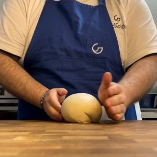 Un uomo che indossa un grembiule con la lettera g sopra