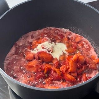 Una pentola piena di fragole e panna montata