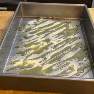 Una padella piena di liquido verde e zucchero a velo