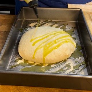 Una palla di pasta in una padella con olio sopra