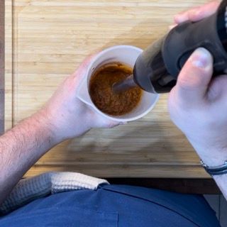 Una persona sta versando qualcosa in una tazza con un cucchiaio