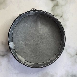 Una tortiera è appoggiata su una superficie di marmo.