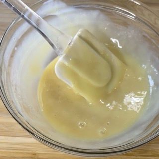 Una ciotola di liquido giallo con una spatola dentro