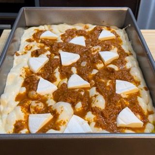 Una padella di cibo con salsa e formaggio sopra