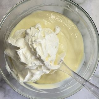 Una ciotola di panna montata con un cucchiaio dentro.