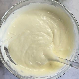 Una ciotola di besciamella con un cucchiaio dentro.