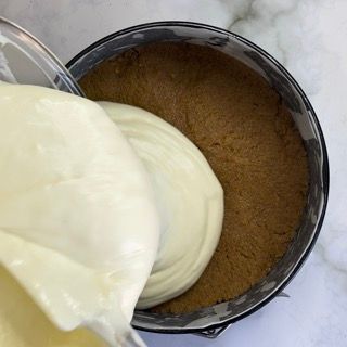 Una persona sta versando la panna montata in una tortiera.