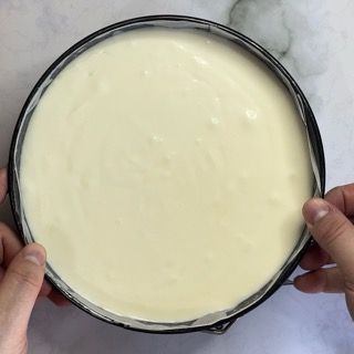 Una persona tiene in mano una pentola di besciamella con un cucchiaio dentro