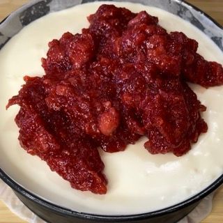 Una ciotola di yogurt con salsa di mirtilli sopra