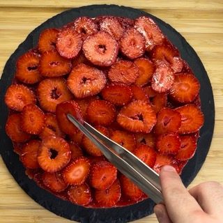 Una persona sta tagliando le fragole con un paio di forbici