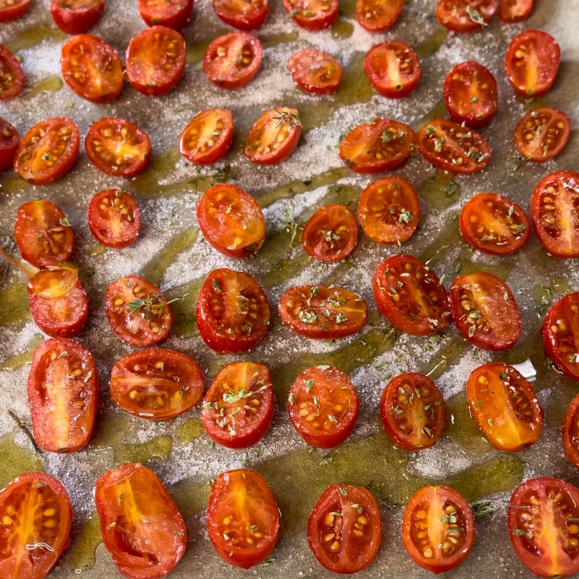 Un mazzo di pomodorini ciliegini appoggiato su un tavolo.