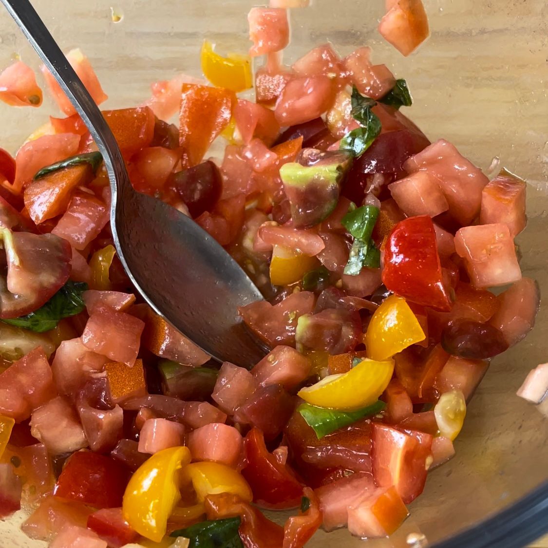 Un cucchiaio è in una ciotola di pomodori e peperoni