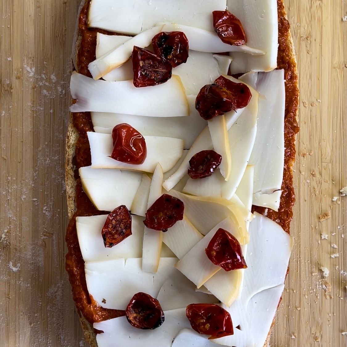 Un pezzo di pane con formaggio e pomodori sopra
