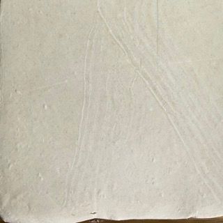 Un pezzo di carta bianca è appoggiato su un tavolo di legno.