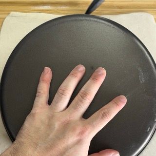 La mano di una persona si allunga verso una padella