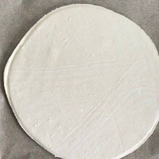 Un cerchio bianco è appoggiato su un pezzo di carta oleata