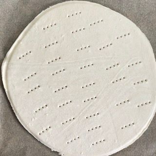 Un cerchio bianco con dei buchi è appoggiato su un tavolo