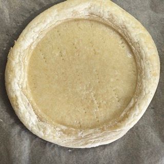 Una crosta di pizza è appoggiata su un pezzo di carta oleata