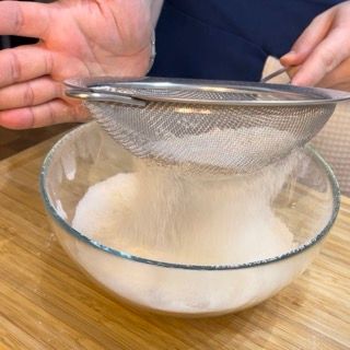 Farina e fecola setacciate in una ciotola