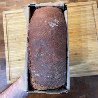 Una pagnotta di pane è appoggiata su un tagliere di legno.