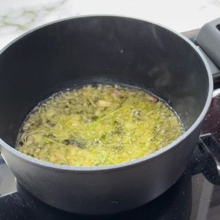 Una pentola piena di liquido è posta sopra un fornello.