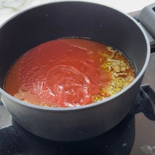 Una pentola piena di salsa di pomodoro e altri ingredienti