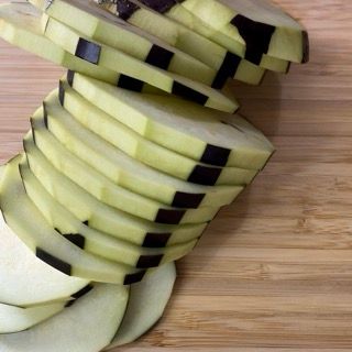 Una pila di mele tagliate a fette su un tagliere di legno