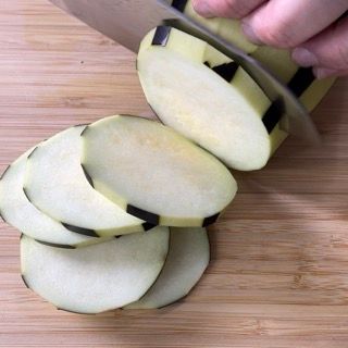 Una persona sta tagliando le patate su un tagliere di legno