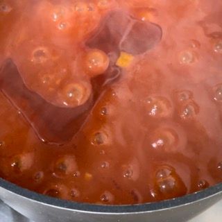 Una pentola di salsa di pomodoro da cui escono le bollicine