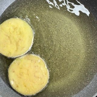 Due patate vengono cotte in una padella con olio.
