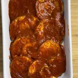 Una casseruola piena di salsa di pomodoro su un tavolo di legno