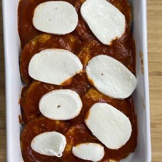 Una teglia piena di salsa di pomodoro e fette di mozzarella
