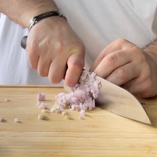 Una persona sta tagliando le cipolle su un tagliere