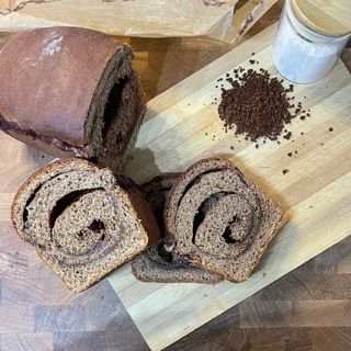 Una pagnotta di pane e due fette di pane su un tagliere