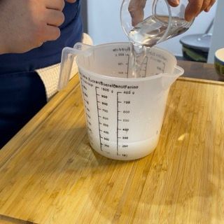 Una persona sta versando del liquido in un misurino