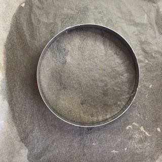 Un cerchio di metallo è posto in cima a un mucchio di terra.