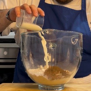 Una persona che versa del liquido in una ciotola con la lettera g sopra