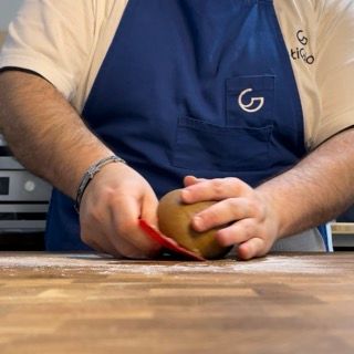 Un uomo che indossa un grembiule con la lettera g sopra