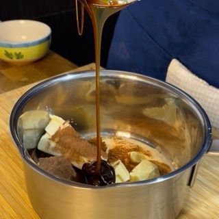 Una persona sta versando del liquido in una pentola di cibo